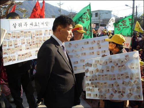 주민들이 반납한 주민등록증에 둘러 싸여 있는 박해룡 서상면장. 천사령 군수는 골프장 관련 담당 공무원을 서상면장으로 발령하여 주민들의 감정을 더욱 자극시키고 있다. 